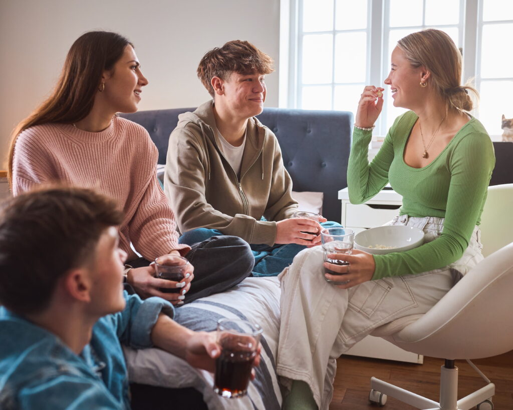 group of teenage girls and boys at home hanging out
