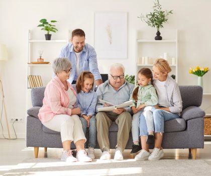 Portrait,Of,A,Happy,Grandfather,Showing,Family,Photo,Album,To