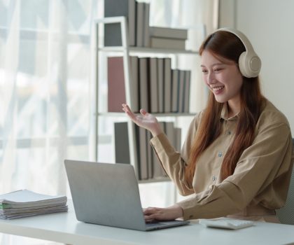 Young,Asian,Woman,Looks,Happy,Wearing,Headphones,Watch,The,Webinar