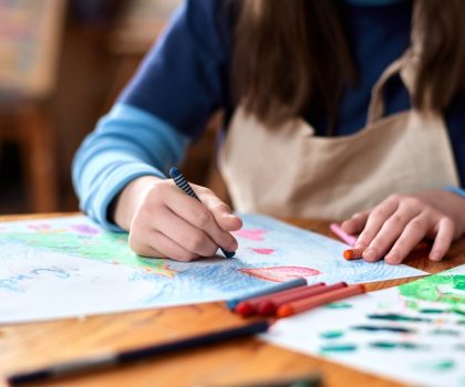Close,Up,Of,Unrecognizable,Teen,Girl,Drawing,Picture,With,Crayons
